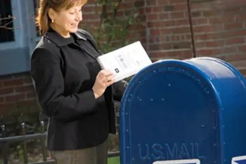 woman using USPS mailbox